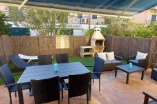 Garden with armchairs, barbecue, table, awnings and sun loungers